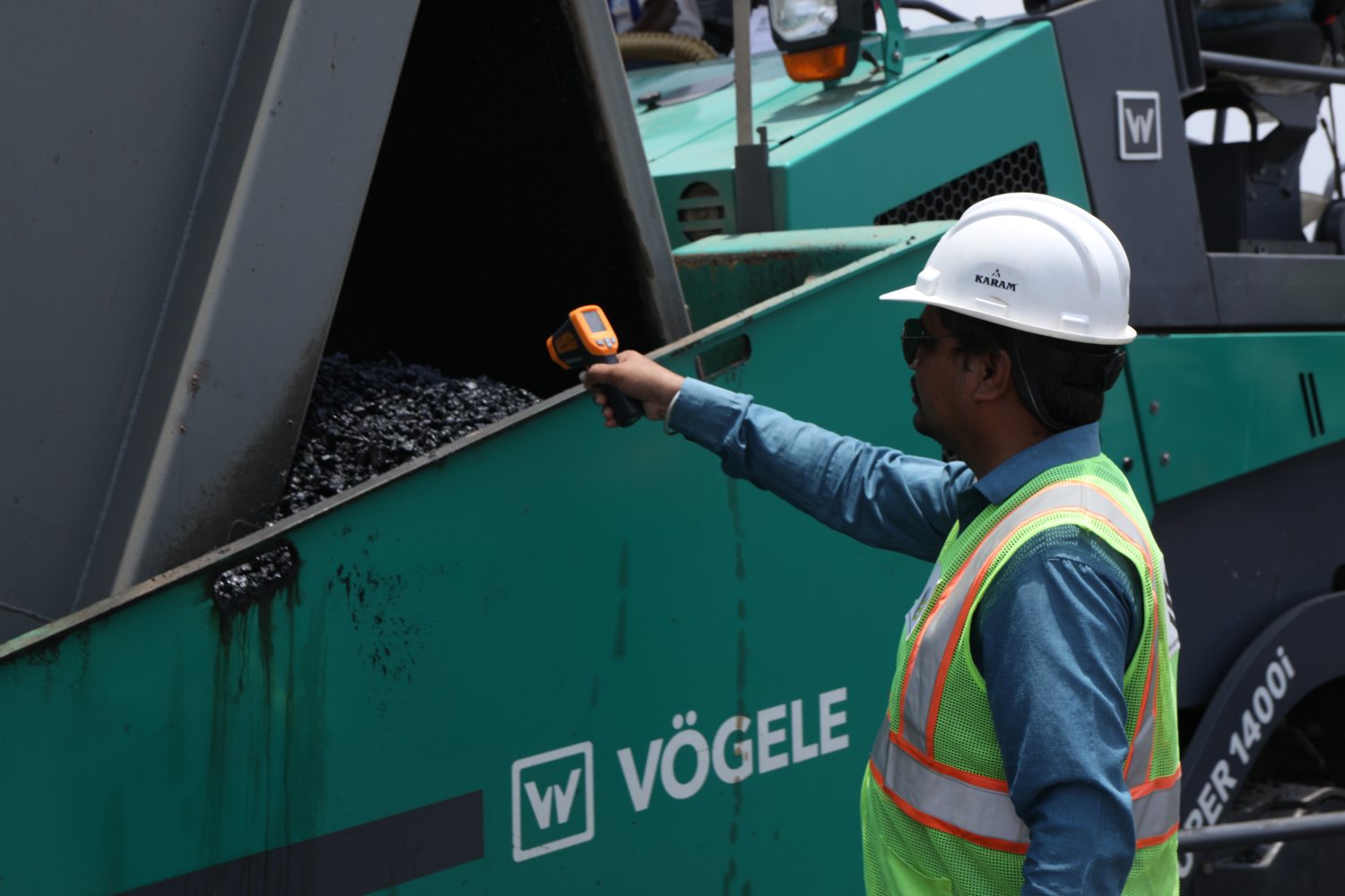 Engineer checking asphalt mix temperature at the Vögele paver